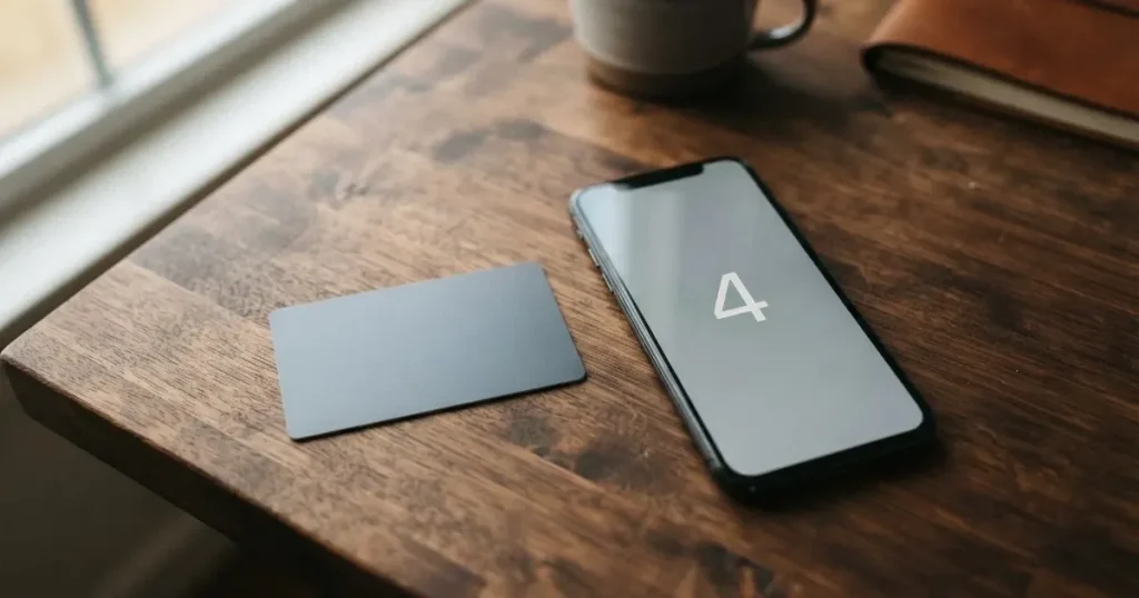 A payment card next to a phone with a crypto wallet app open